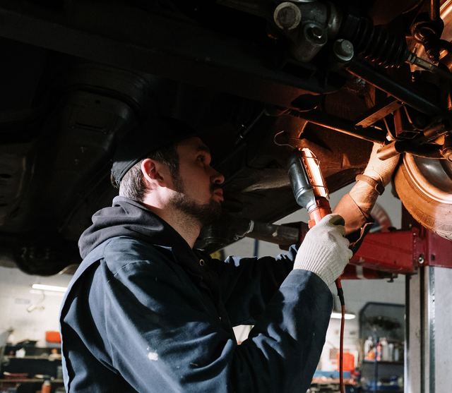 Een mechanieker bekijkt de ophanging van een wagen